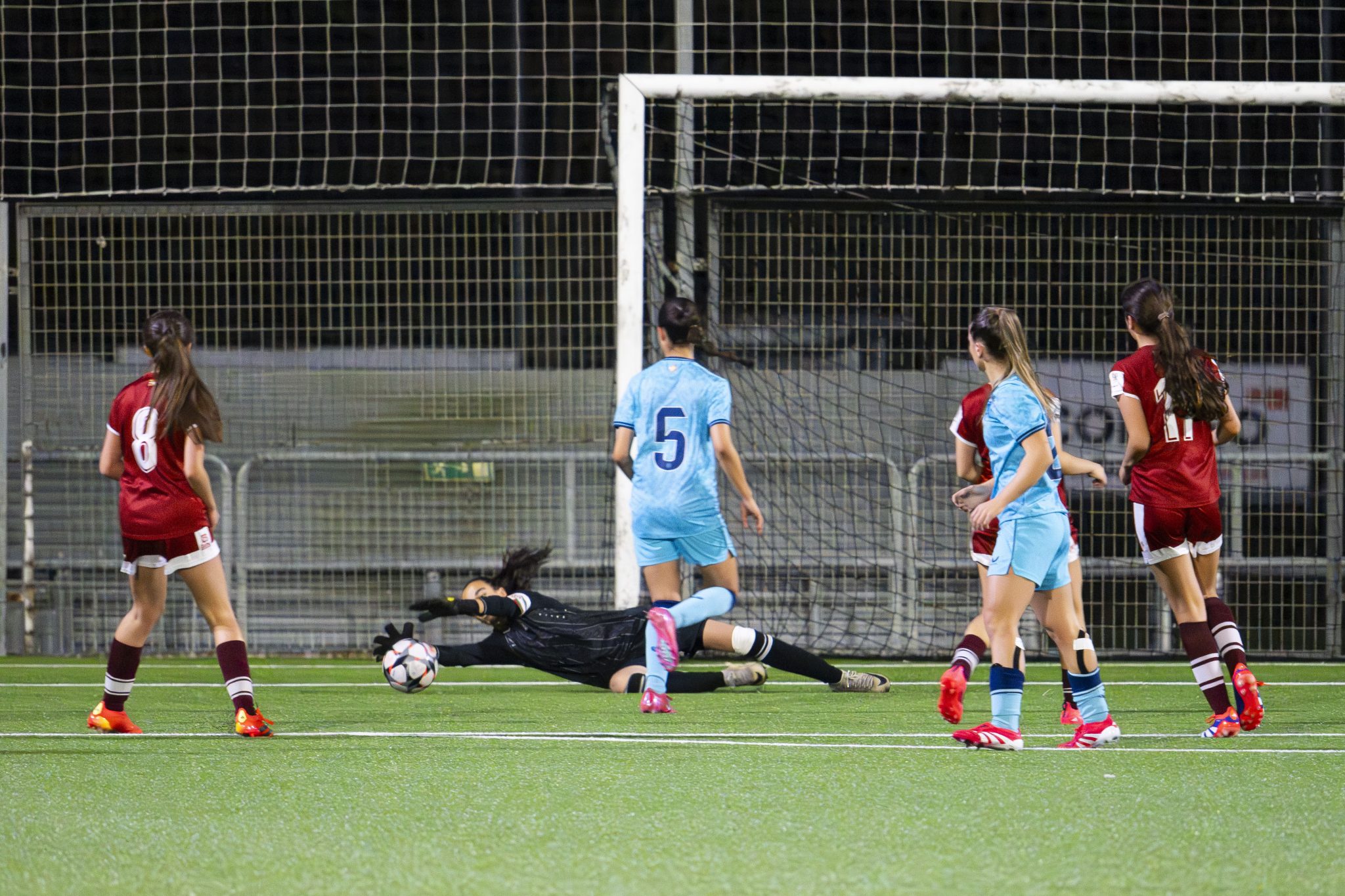 A goalkeeper diving to stop a close-range shot