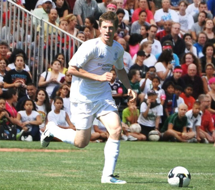 Footballer carrying the ball forward under pressure